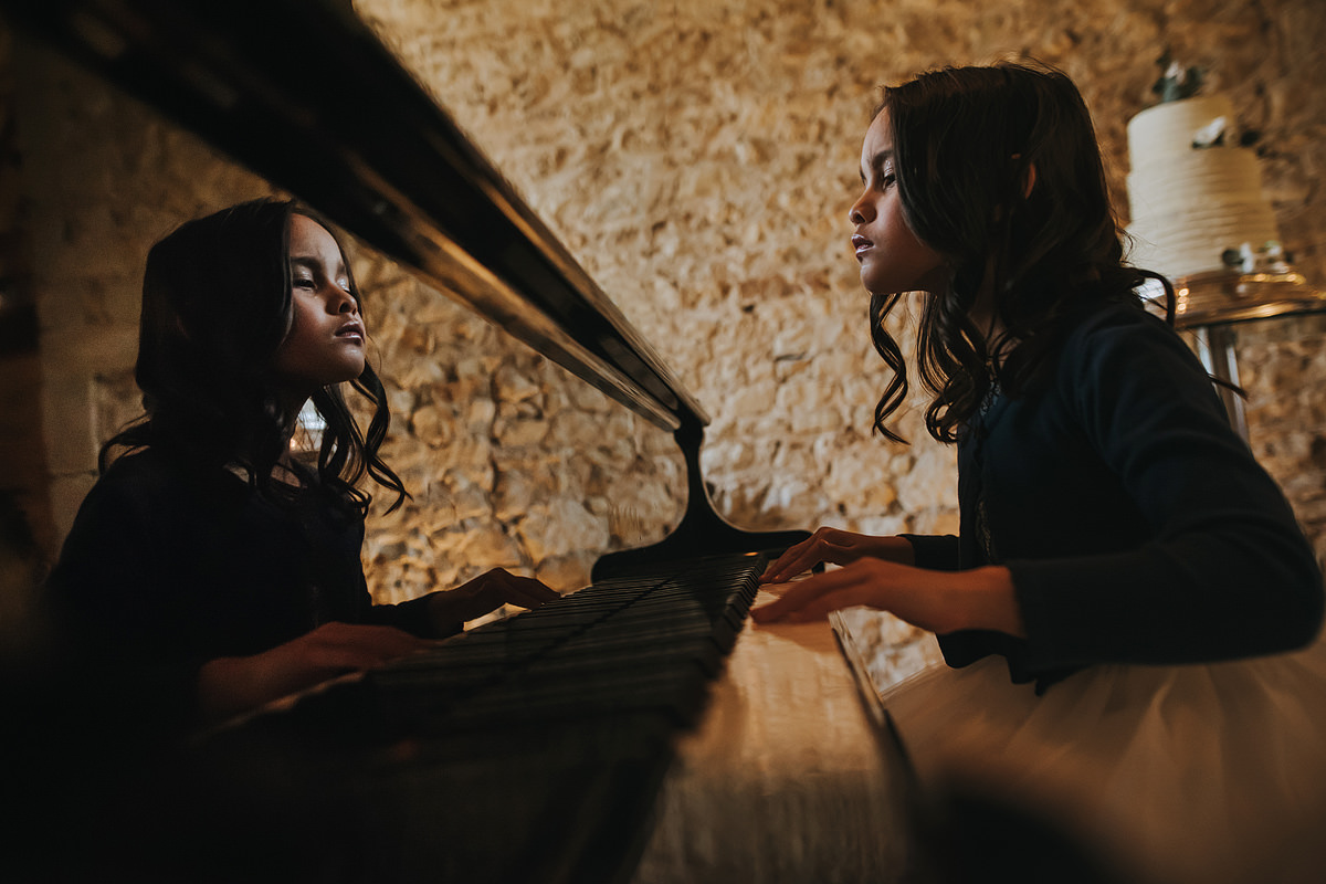 Flower girl plays piano at a Notley Abbey wedding