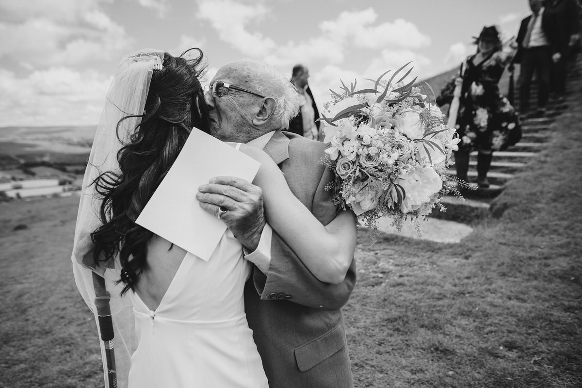 Emotional grandad hugging bride