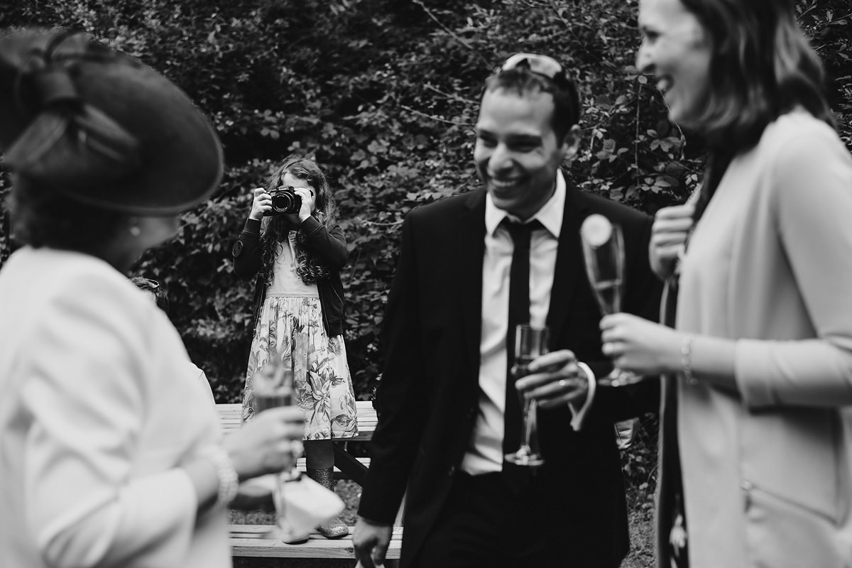 Flower girl taking photos at a wedding